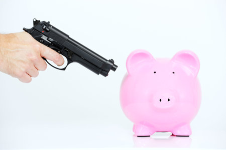 pink piggy bank and hand with gun
