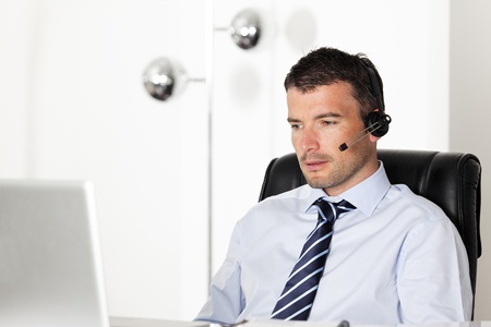 man in office with laptop and headsetの写真素材