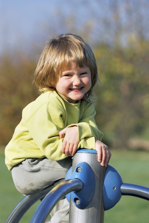 young child playing on colorful playground in a parkの写真素材