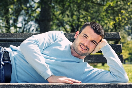 relaxed handsome man on a bench in a parkの写真素材