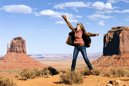 happy cowgirl jumping at Monument Valley, Utah, USAの写真素材