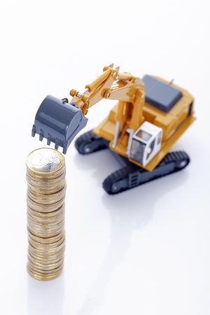 making euro money coins with digger isolated on white background の写真素材