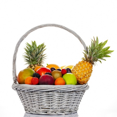 Composition with assorted fruits in wicker basket on white backgroundの写真素材