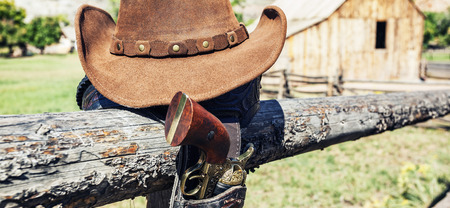cowboy gun and hat outdoor in a ranch, panoramic viewの写真素材
