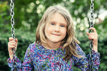 child on swing in summer park