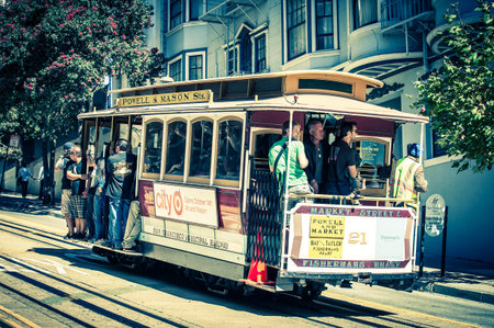 Powell Hyde cable car, an iconic tourist attraction, descends a steep hill overlooking Alcatraz prison and SF bay on October 6, 2012 in San Francisco, USA のeditorial素材