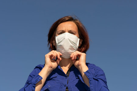 woman adjusting her mask outdoor