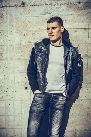 Photo of handsome man posing in front of a wall