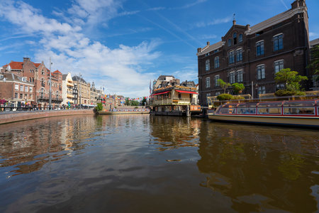 AMSTERDAM, NETHERLANDS - AUGUST 23 2022, Famous cityscape with boat in Amsterdamのeditorial素材