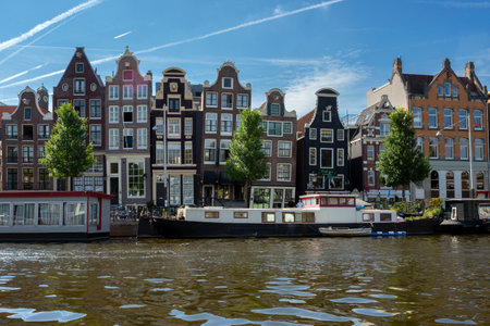 AMSTERDAM, NETHERLANDS - AUGUST 23 2022, Famous cityscape with boat in Amsterdamのeditorial素材