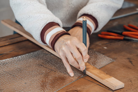hand of female master glassmaker at work in a workshop, France