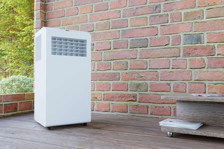 mobile air conditioner in a brick room with a windowの写真素材