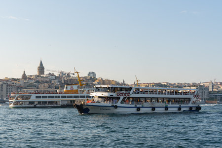 ISTANBUL, TURKEY, JUNE 6, 2023: Two ferries warm up with each other in the Bosphorus Strait against the background of the old city in the distance and the blue sky Strait between two continentsのeditorial素材