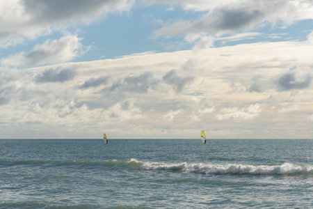 Windsurfers try to catch a fair wind in the open sea, water sports, water activities on a sunny winter dayの写真素材
