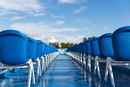 Blue empty plastic chairs on a platform. High quality photo