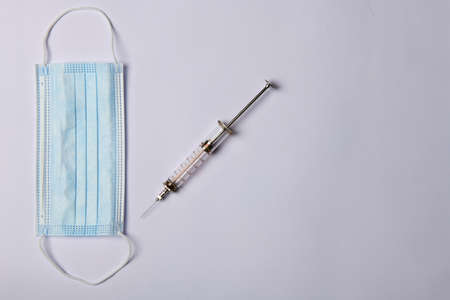 blue medical mask and syringe on white backgroundの写真素材