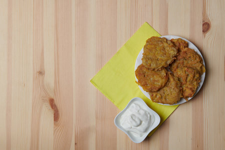potato pancakes in a plate and a cup of coffee on a wooden background