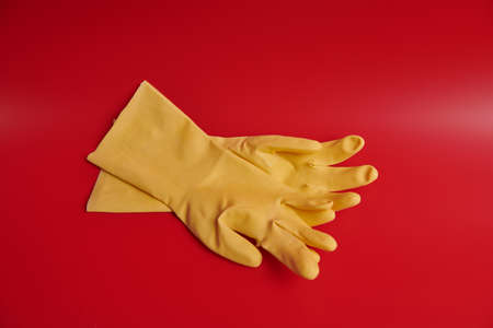 yellow rubber gloves on a red backgroundの写真素材