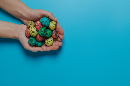 many colored eggs in the palms for easterの写真素材