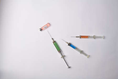 medical syringes and covid vaccine on white backgroundの写真素材