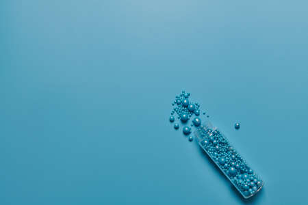 glass jar and blue balls of different diameters on a blue backgroundの写真素材