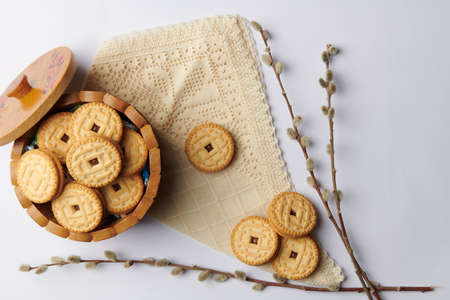 cup with round cookies on a napkin and willow sprigs on a white backgroundの写真素材