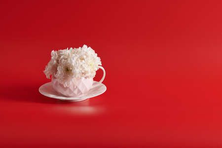 pink cup and saucer with flowers on a red backgroundの写真素材