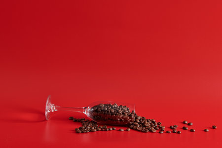 wine glass and grains of coffee on a red backgroundの写真素材