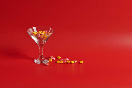 a glass of wine stands with multicolored sweetsの写真素材