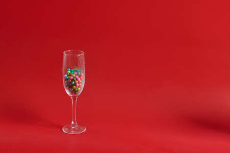 wine glass stands with round multicolored round chocolatesの写真素材