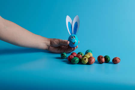 Easter eggs and egg with ears on a blue backgroundの写真素材