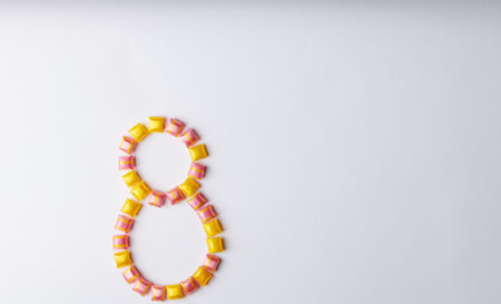 number eight made from red-yellow square candies on white background