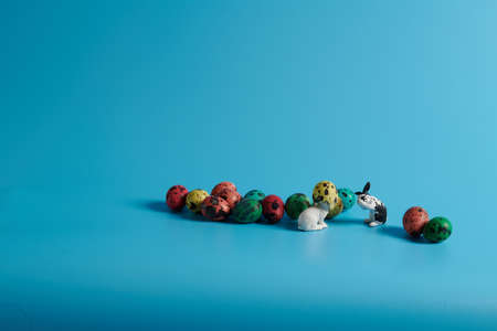 bunnies and colorful Easter eggs on a blue backgroundの写真素材