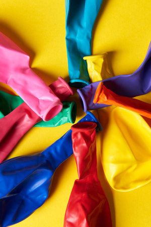 multicolored balloons lie in the center on a yellow background