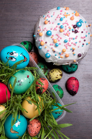 Easter cake and red yellow green and blue eggs lie on the background