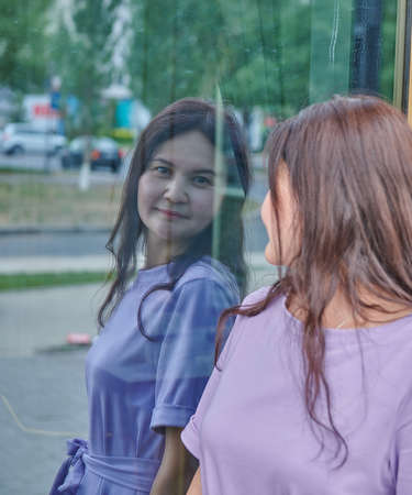 cute girl reflection in the glass showcaseの写真素材