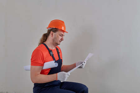 a very angry electrician looks at the blueprints of the projectの写真素材