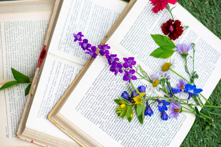 books lie on the lawn with flowers