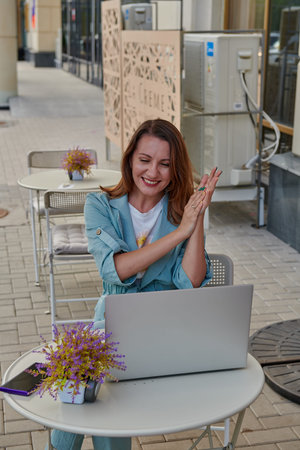 perky girl at a table in a cafe with a laptop
