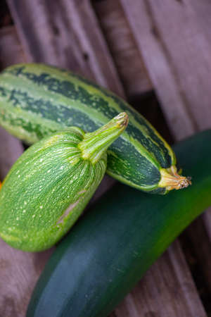 several green zucchini lie on a wooden onetの写真素材