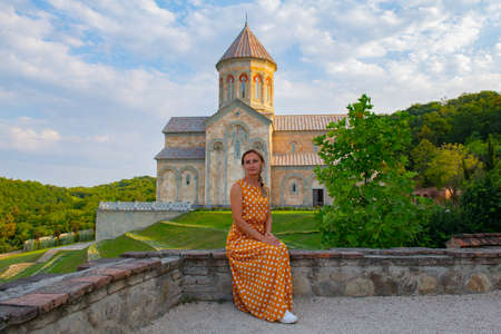 a woman sits on the parapet of a monastery in sighnaghiの写真素材