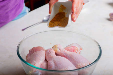 chicken drumsticks in a cup sprinkled with seasoningの写真素材