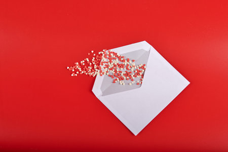 white envelope with red and white hearts on a red background