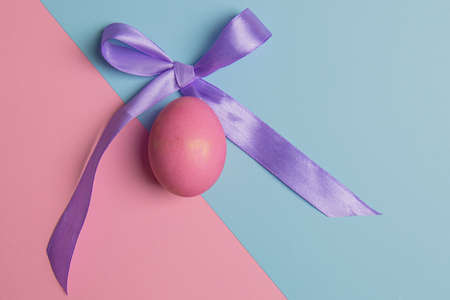 easter pink egg and lilac bow on backgroundの写真素材