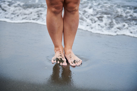 on black sand two womens feet standの写真素材
