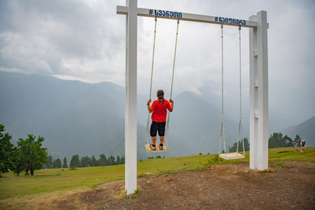 Thrill of Flight: Man Swinging Wildly in Orange T-Shirt