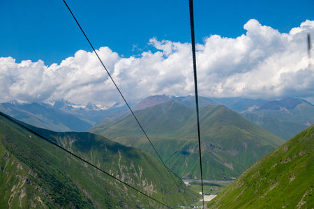 Cloud-kissed Heights: Green Mountains Soaring Toward Blue Skies