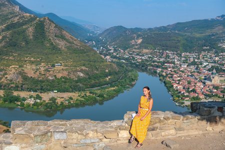 a girl sitting at the confluence of the Kura and Aragvi riversの写真素材