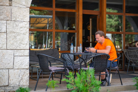 the Man in orange sitting in cafeの写真素材