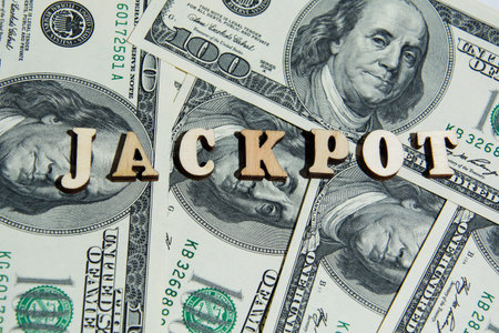The word Jackpot on the 100 us dollar bills background. Macro view 100 dollar banknotes. Casino or...